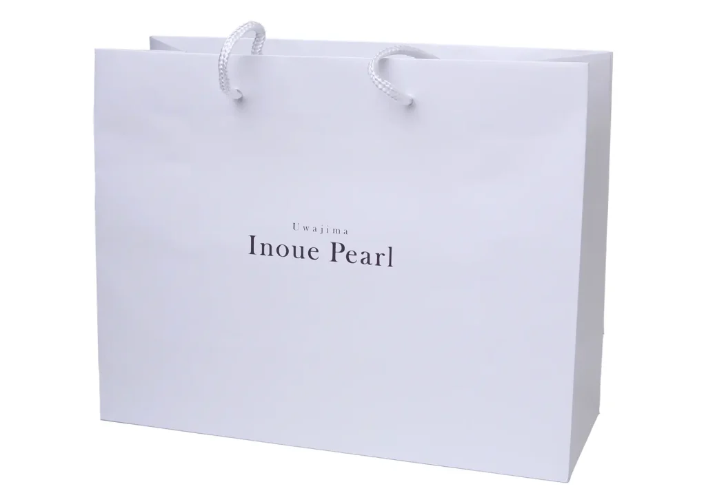 Uwajima Inoue Pearl のロゴが入った白い手提げ紙袋